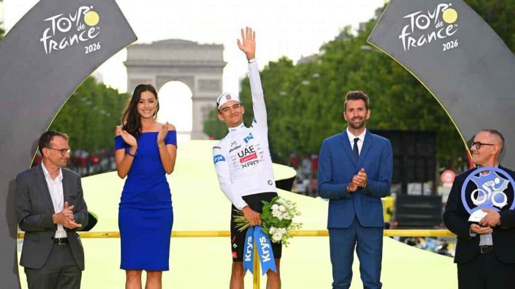 Isaac del Toro celebra su tercer lugar en el Tour de Francia 2026, rodeado de autoridades y con el Arco del Triunfo al fondo.