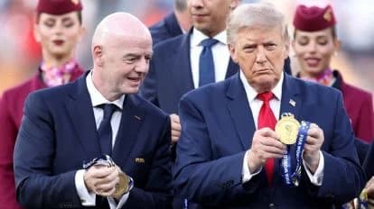 Gianni Infantino y Donald Trump sostienen medallas en un evento, mientras otros asistentes observan con atención.